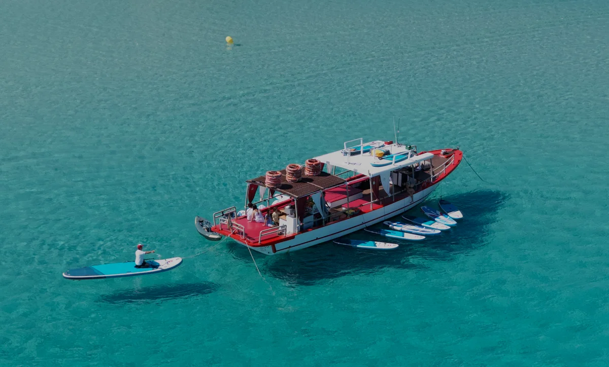 Top-down luchtfoto van Salvador Ibiza in Cala Comte met gast op paddleboard bij de achterplecht