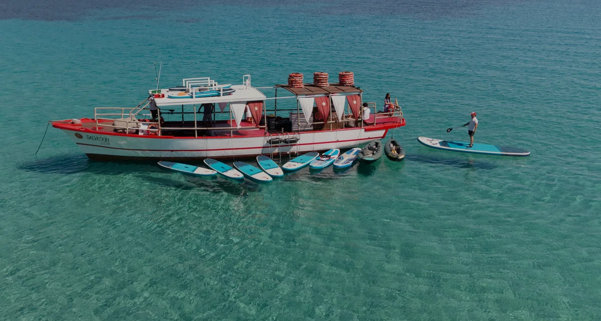 Luchtdrone-opname van Salvador Ibiza voor anker in Cala Comte met paddleboards en kajaks